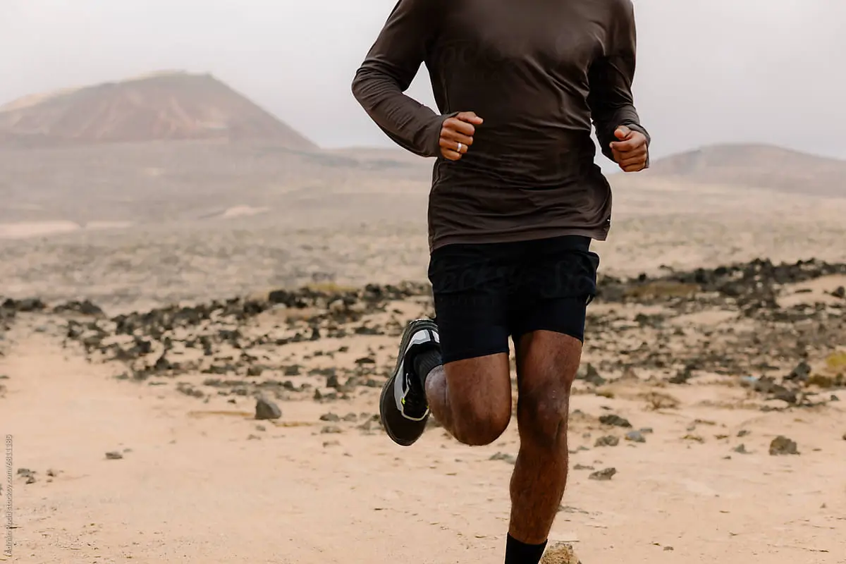 Runner moving fast across a rocky desert landscape during endurance training related to niacin vs nmn energy support.