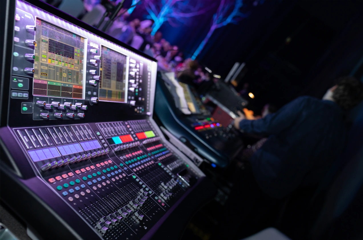 Audio engineer adjusting a large mixing console during a Bad Bunny Grammy live performance setup.