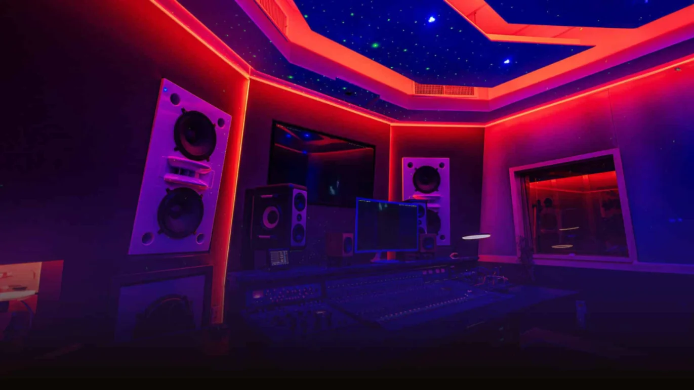 Neon lit recording studio with speakers and desk creating sounds for a Bad Bunny Grammy production.